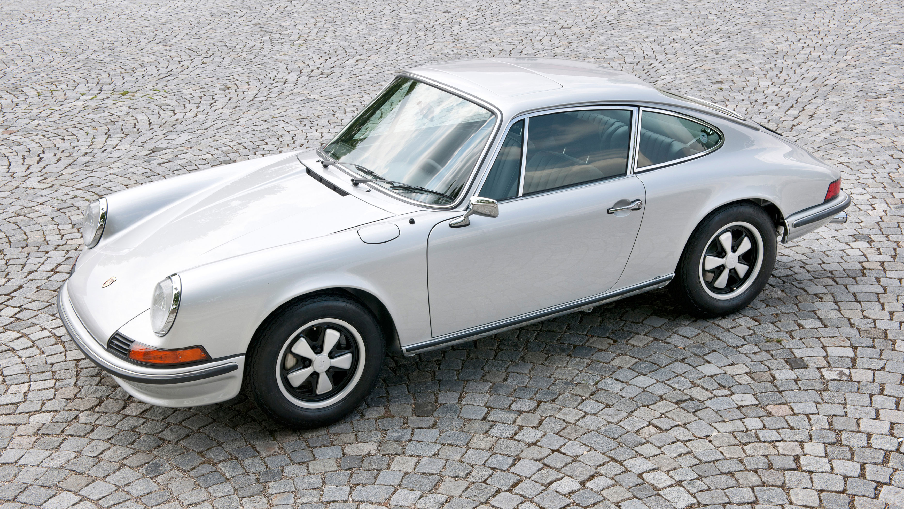 Silver 911 F Model with Fuchs wheels parked on cobbles