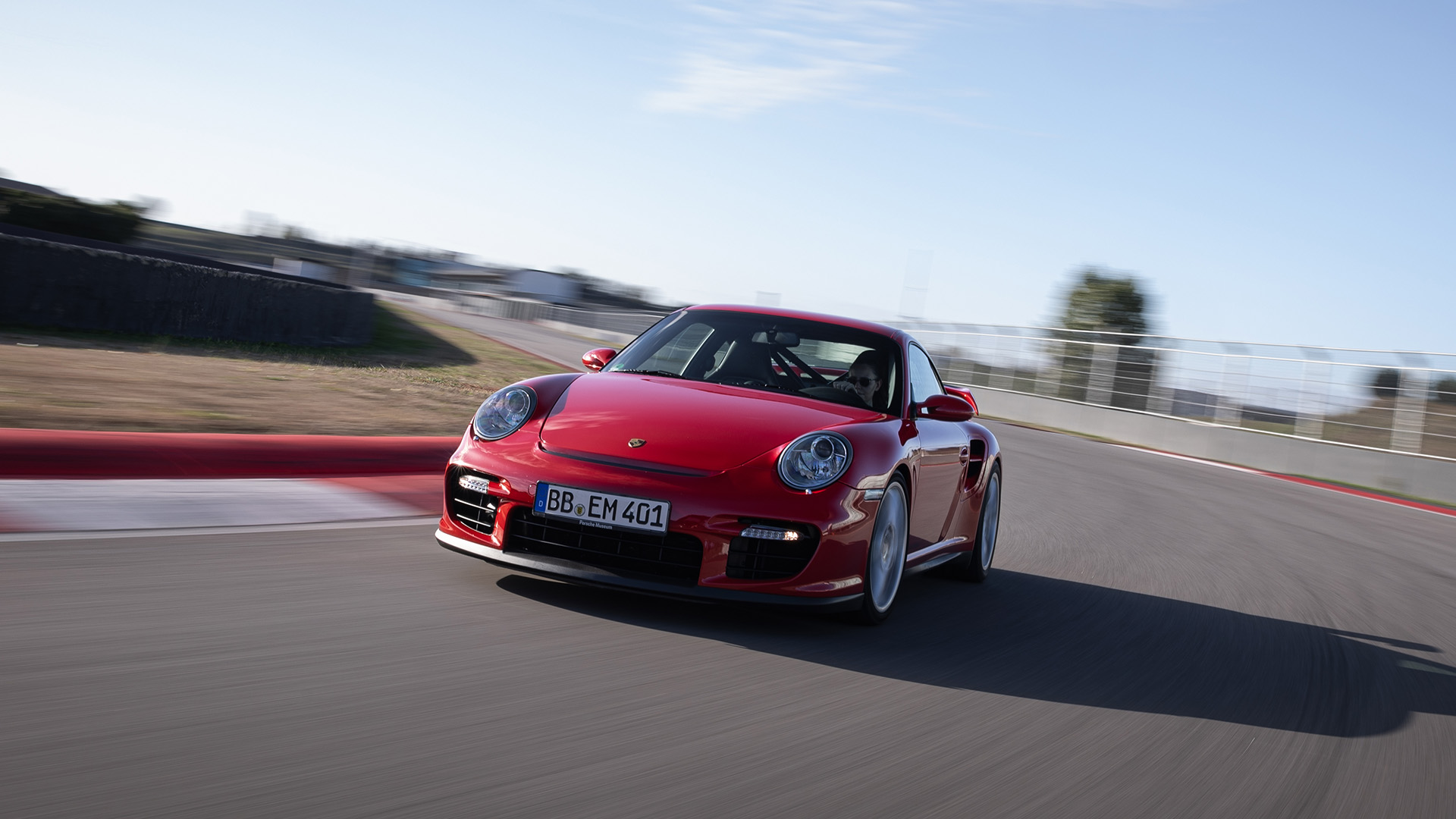 Porsche 911 GT2 type 997 red cornering on racetrack_desktop