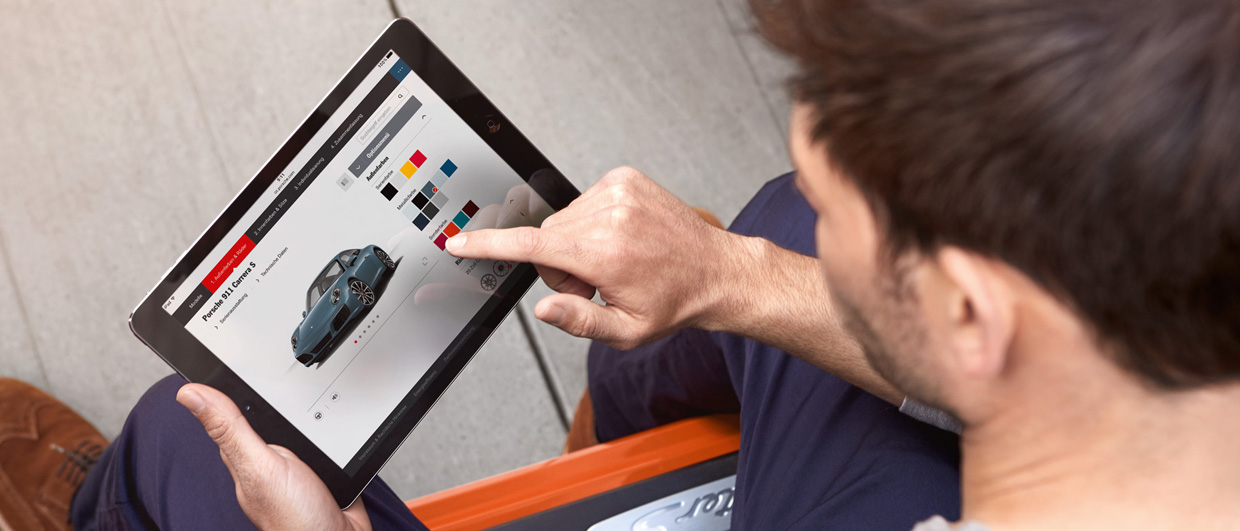 Man digitally configures Porsche Taycan on a tablet