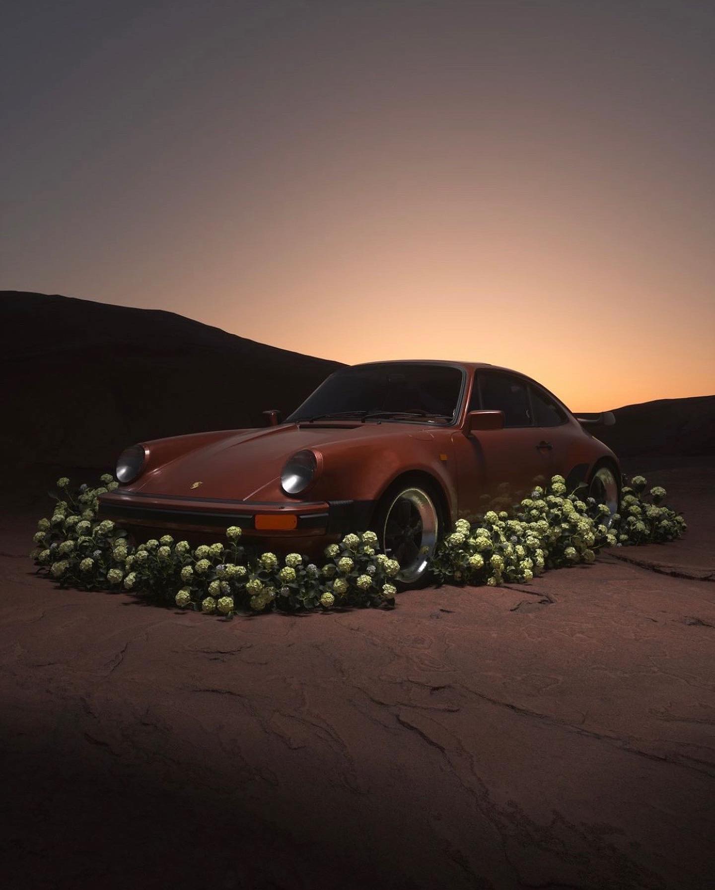Porsche 930 in desert at dusk, surrounded by flowers