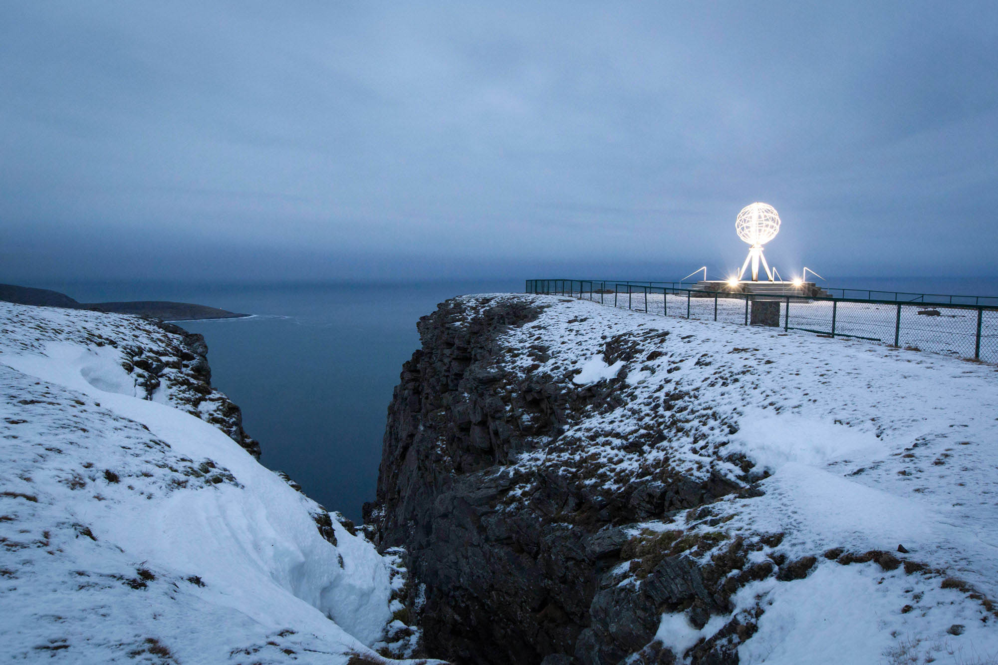 Dark and snowy North Cape with globe statue in background