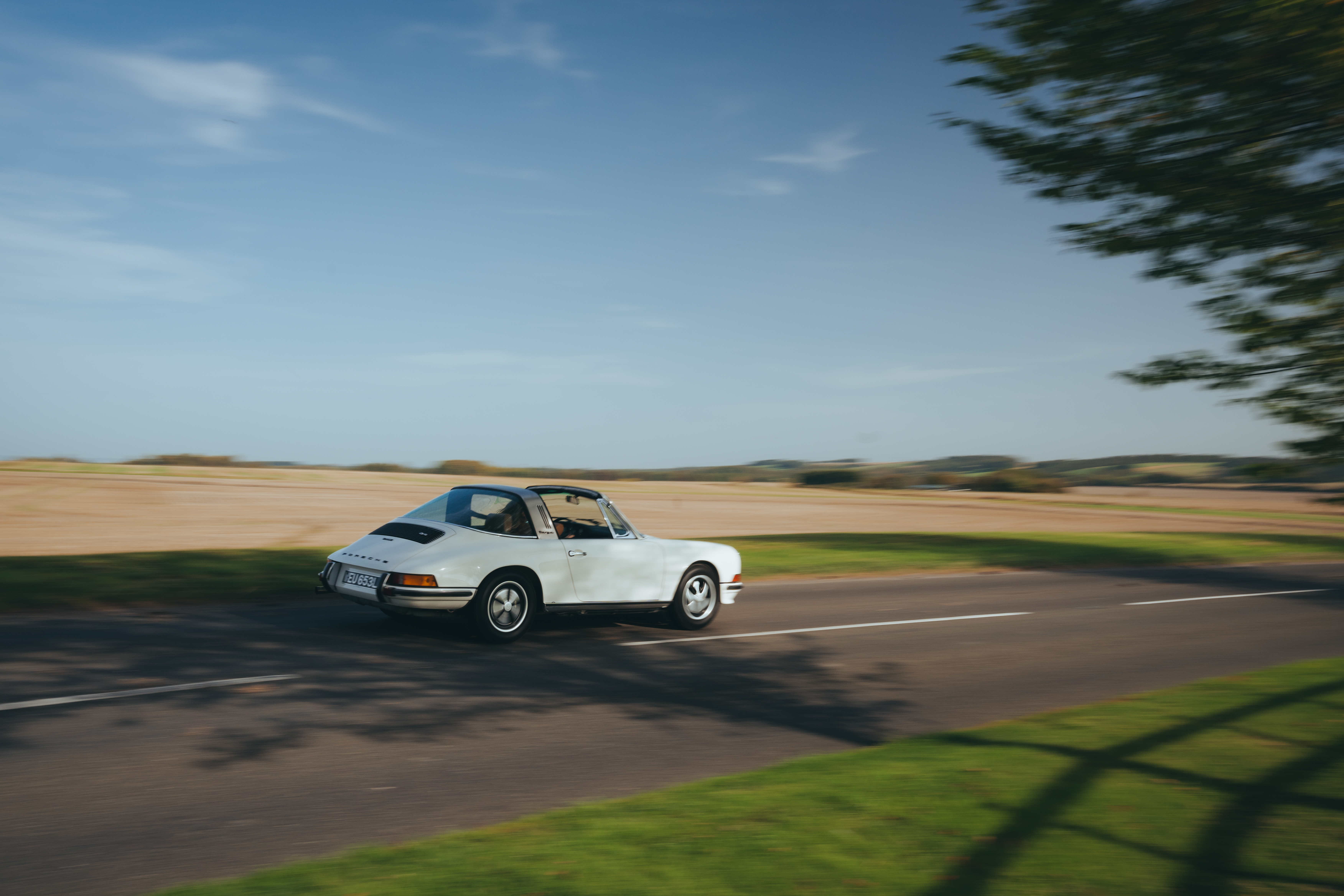 White classic Porsche 911 Targa on sunlit English country road