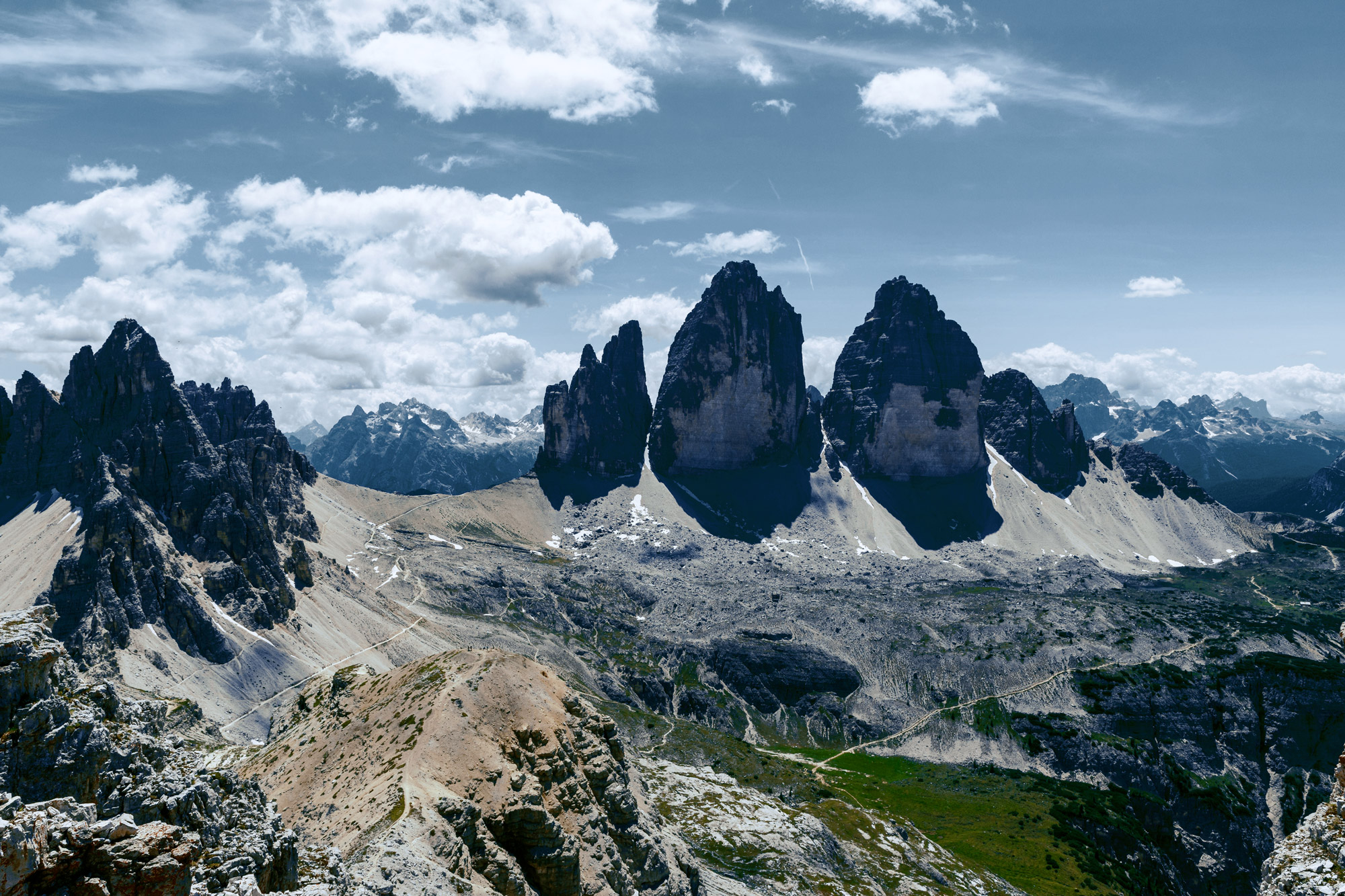 Three large vertical rock faces on a mountain massif
