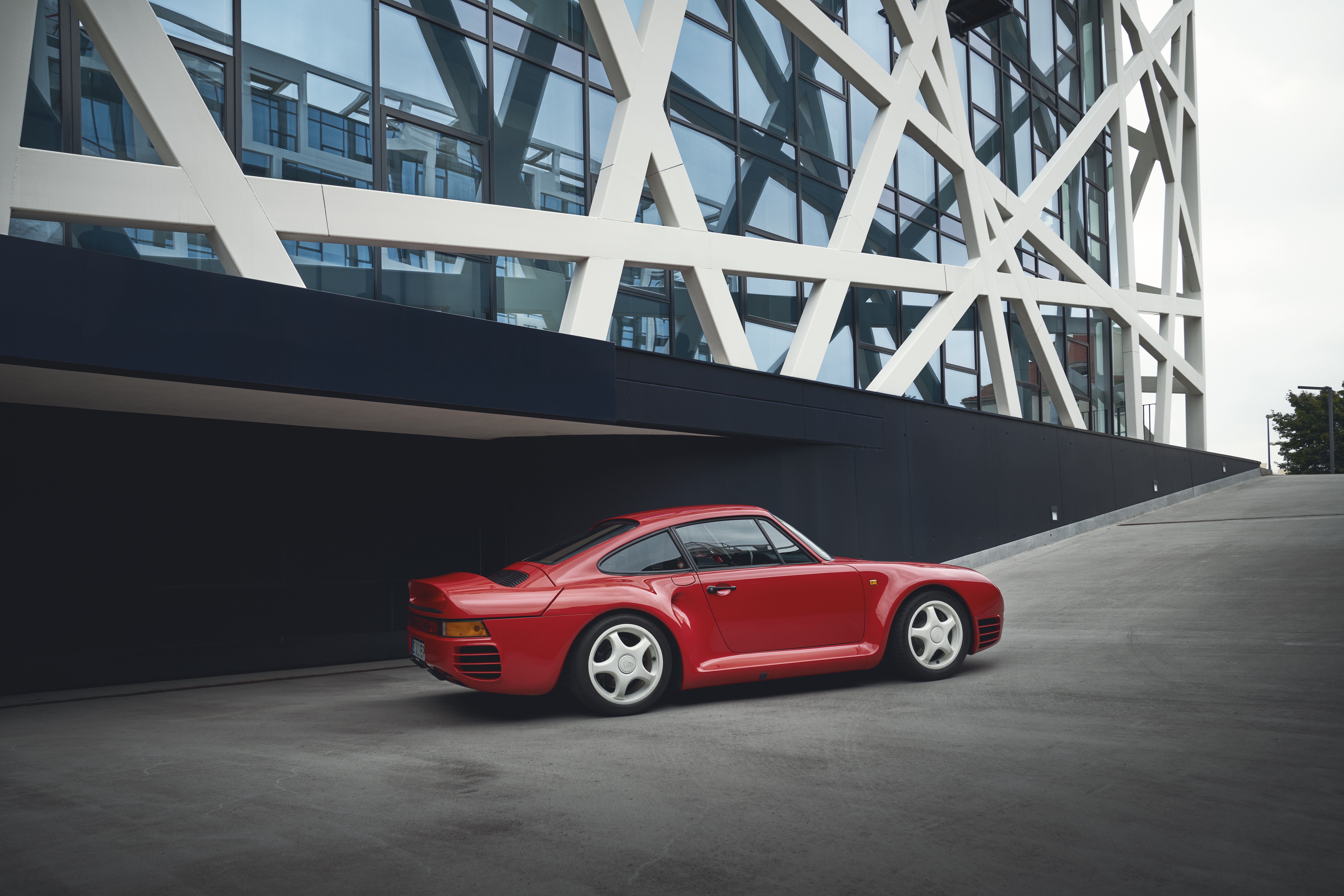Red Porsche 959, rear three-quarter view, driving up slope