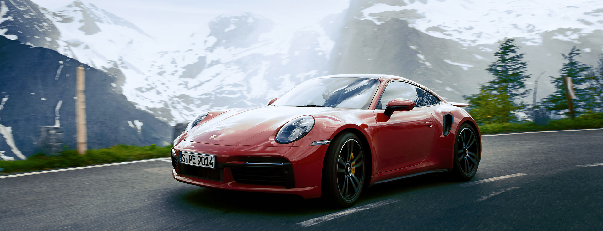 Porsche 911 turbo s driving in front of a mountain range
