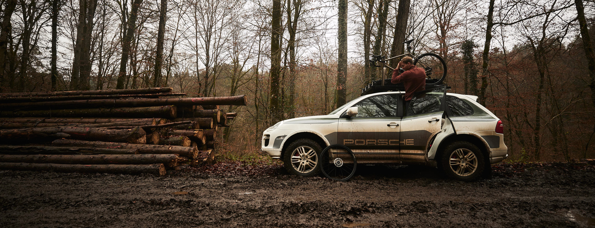 First-generation Cayenne with bike rack next to stack of logs