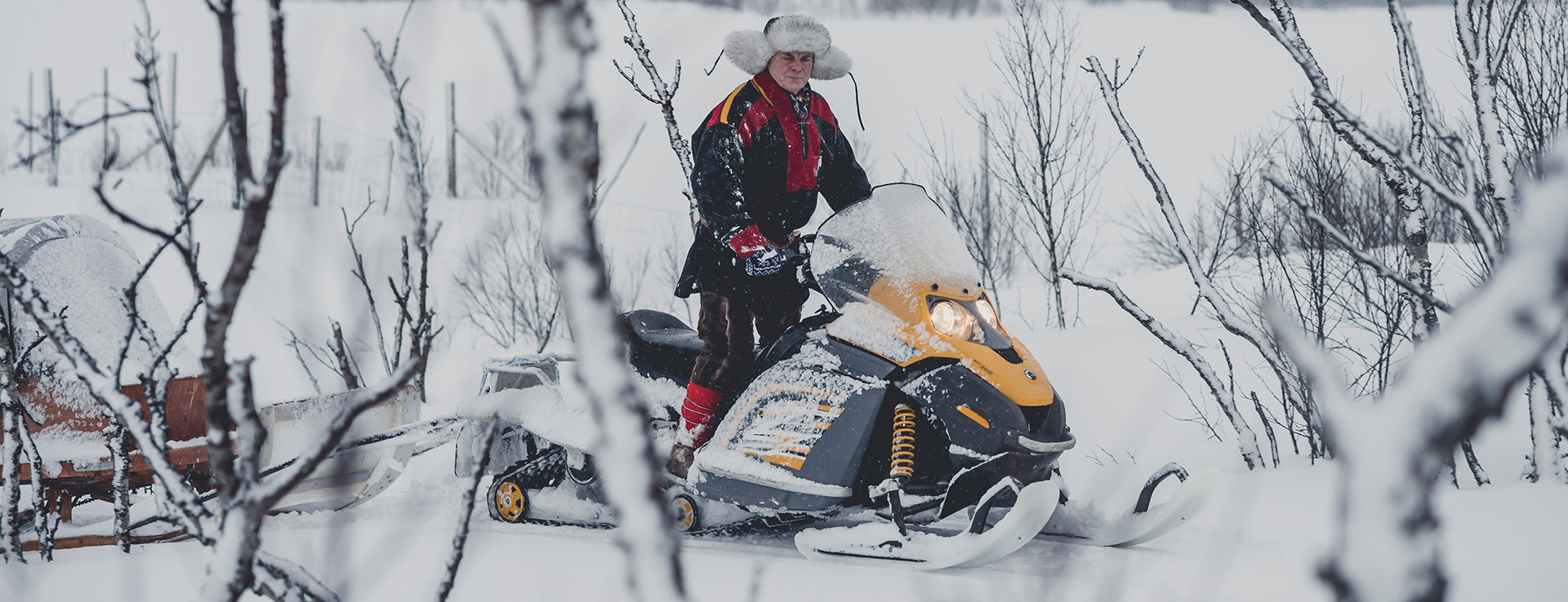 Man in Sami costume on a snowmobile