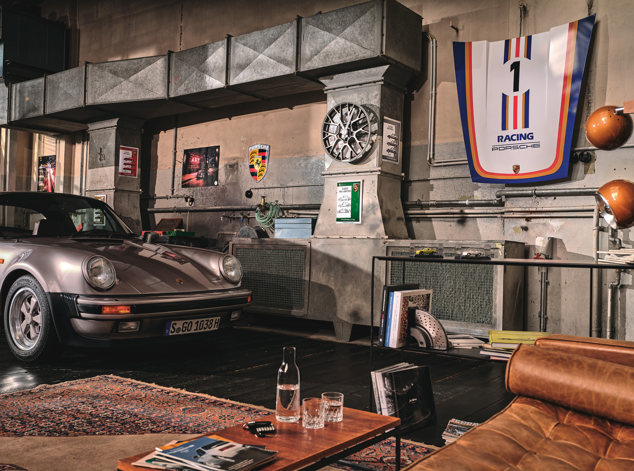 911 motorsport hood and classic Porsche in a sophisticated garage