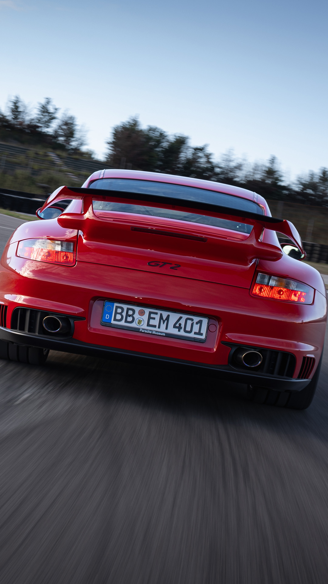 Rear view of Porsche 911 GT2 type 997 red cornering on racetrack_mobile