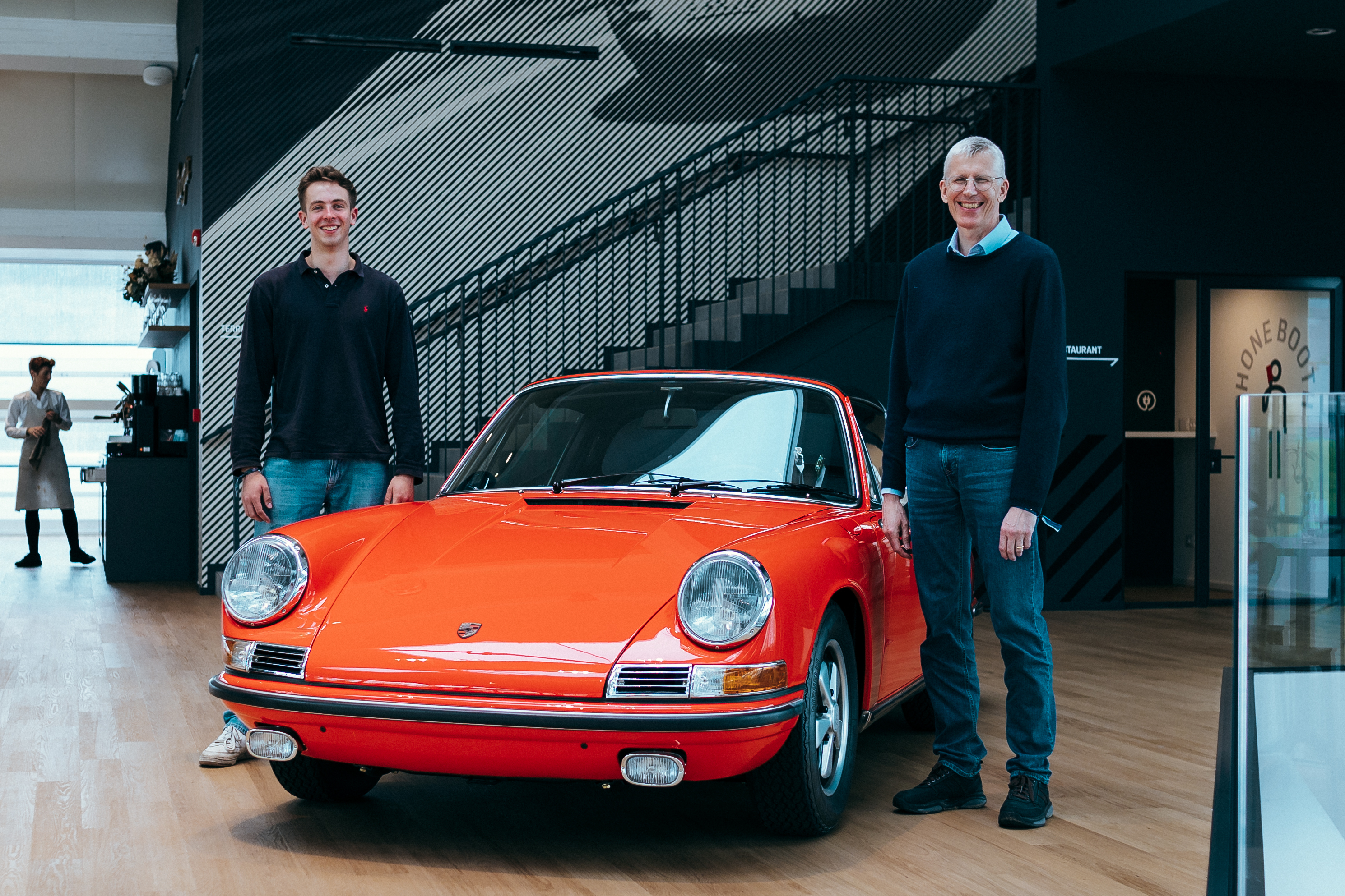 Two men with classic original Porsche 911 in Bahia Red