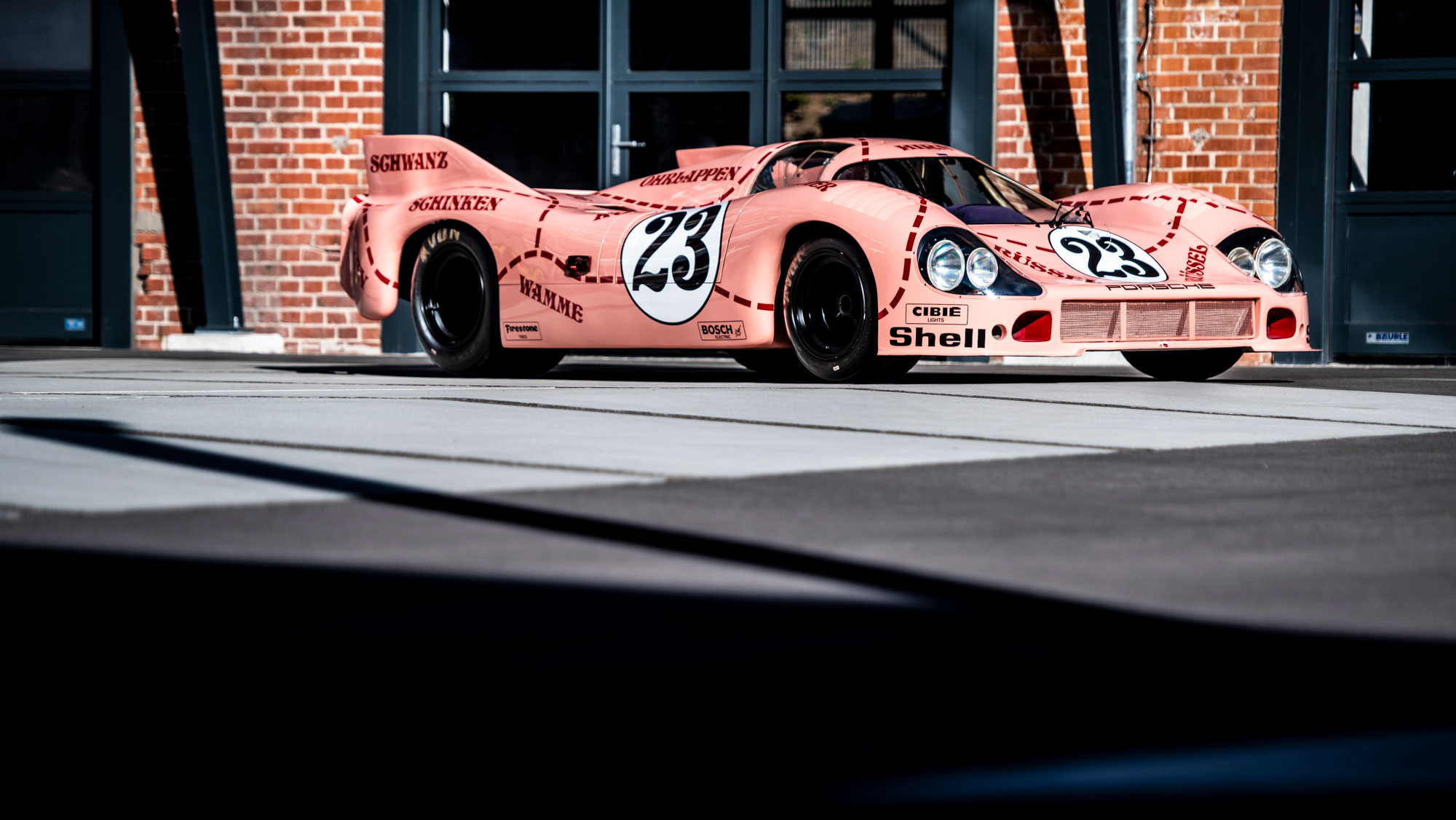 Porsche 917/20 ‘Pink Pig’ in front of brick building