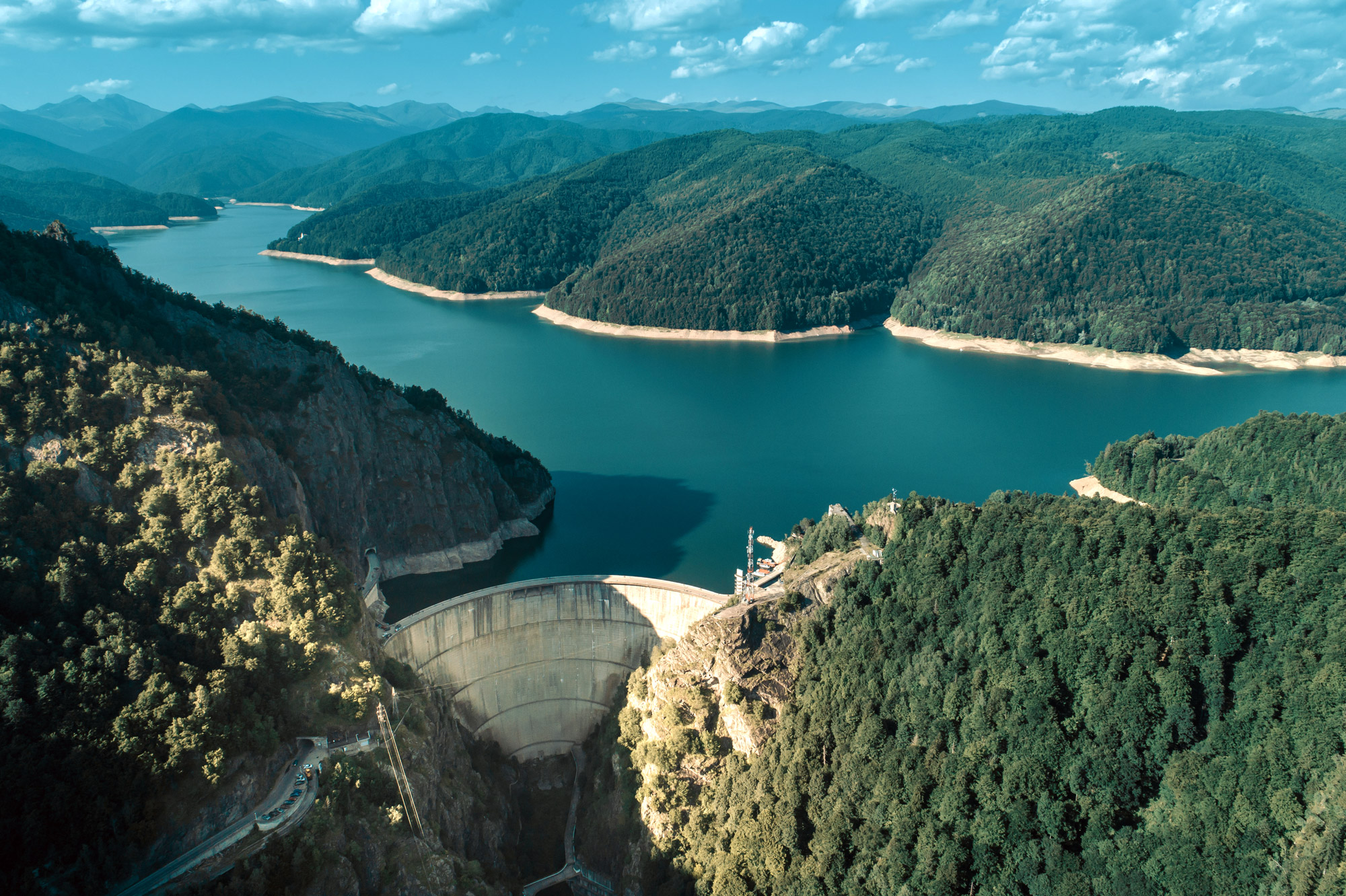 View of lake and forests with dam in foreground