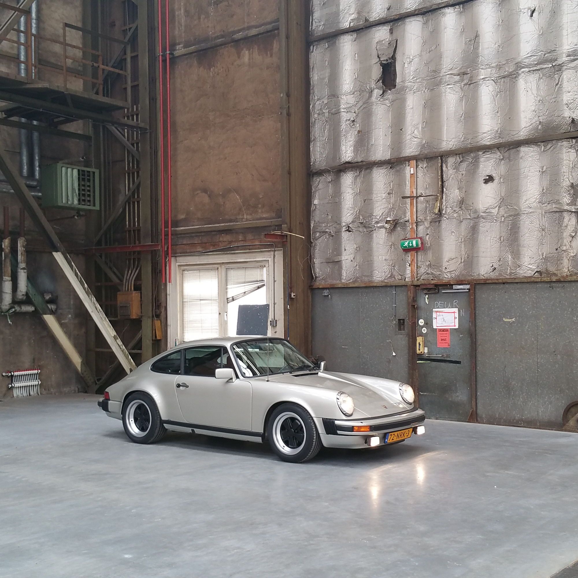 Zinmetallic Porsche 911 SC, three-quarter view, in a hangar