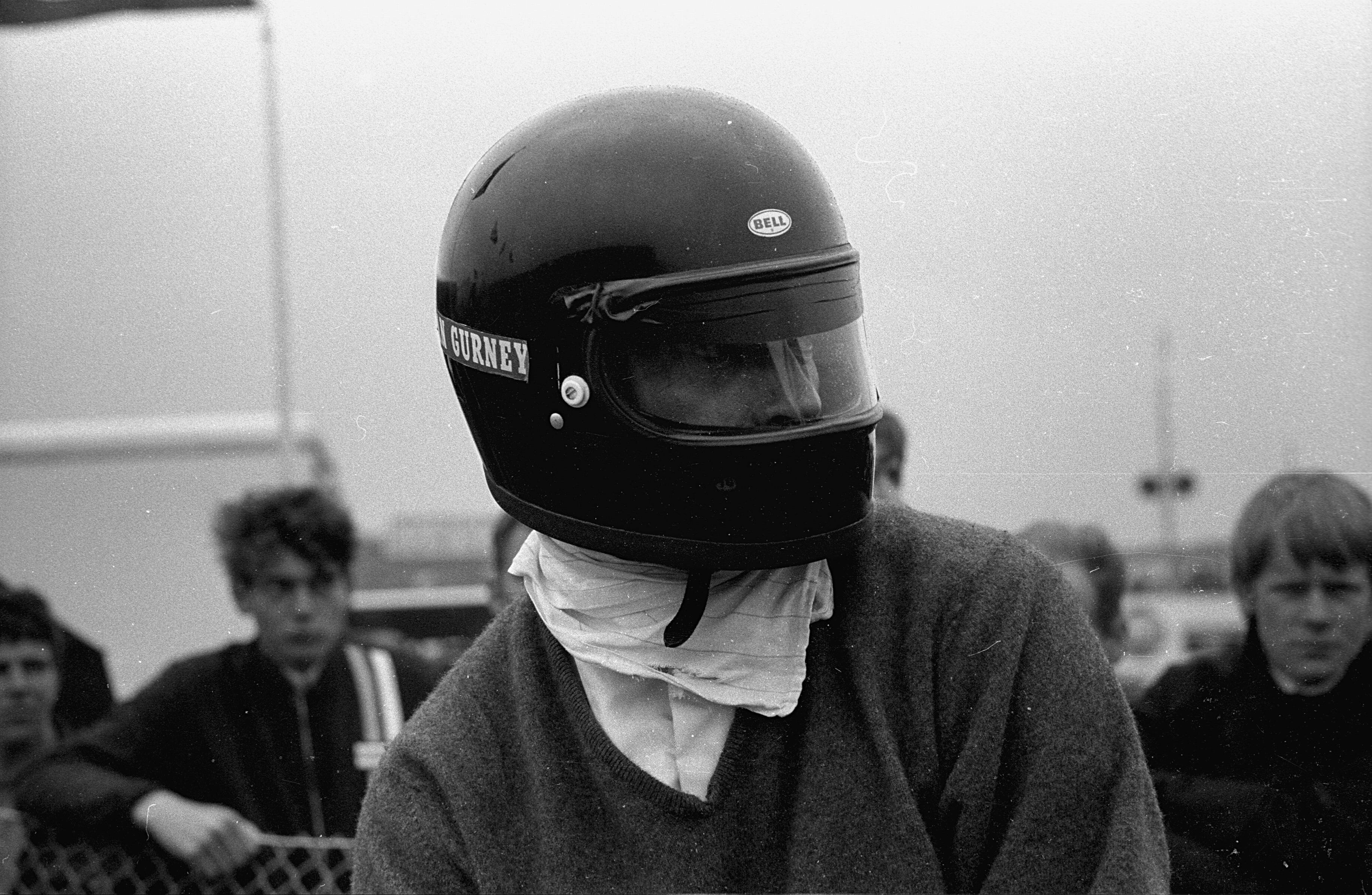 Black and white photo of man wearing all-black helmet 