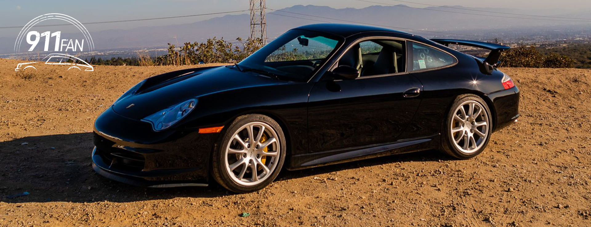 Black 911 (996) GT3 on gravel, mountains behind
