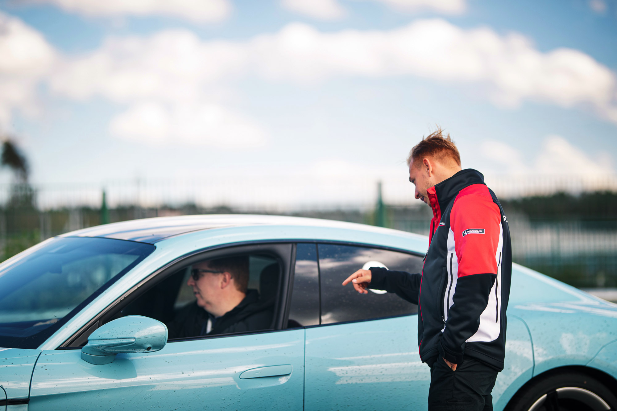 Porsche instructor giving instructions to a driver in a Taycan