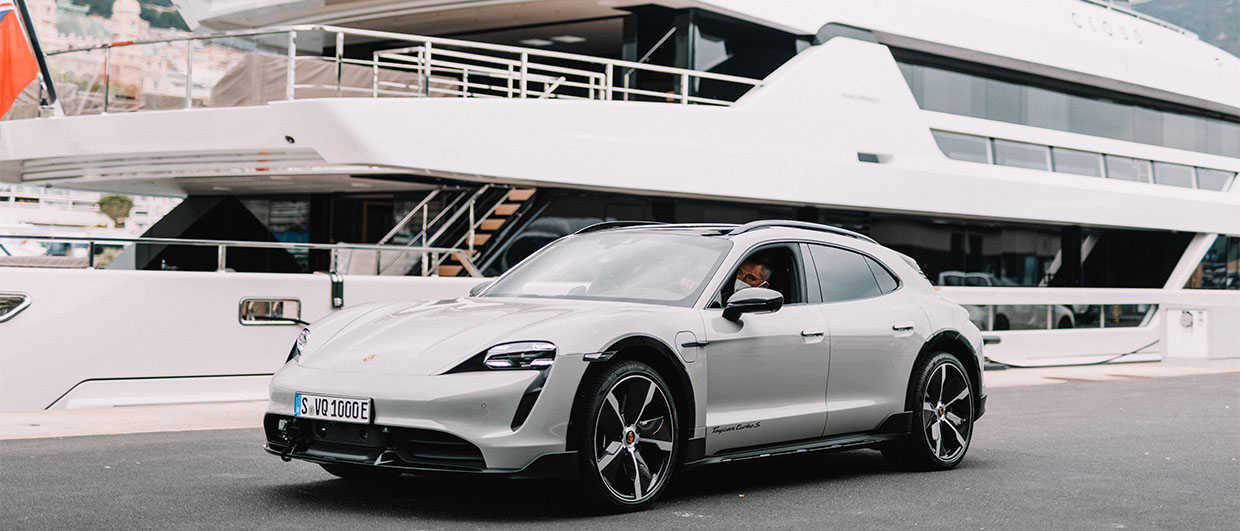 Porsche Taycan Cross Turismo parked beside a yacht in Monaco