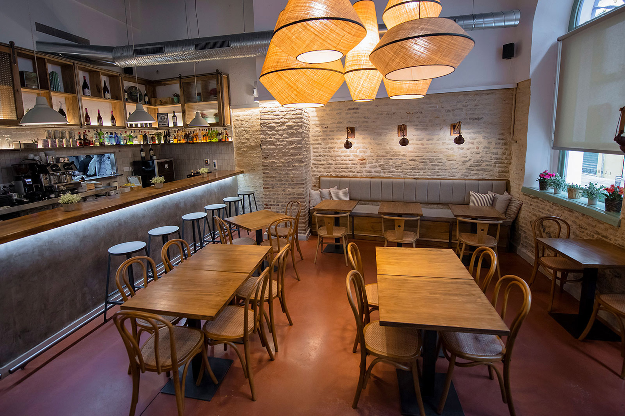 Interior of a high-ceilinged tapas bar with wicker lampshades
