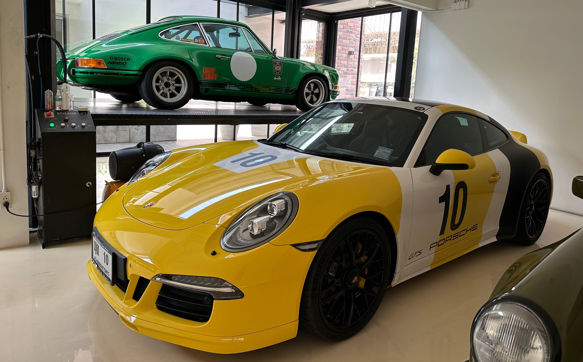 A pair of Porsche 911 sportscars in a private garage