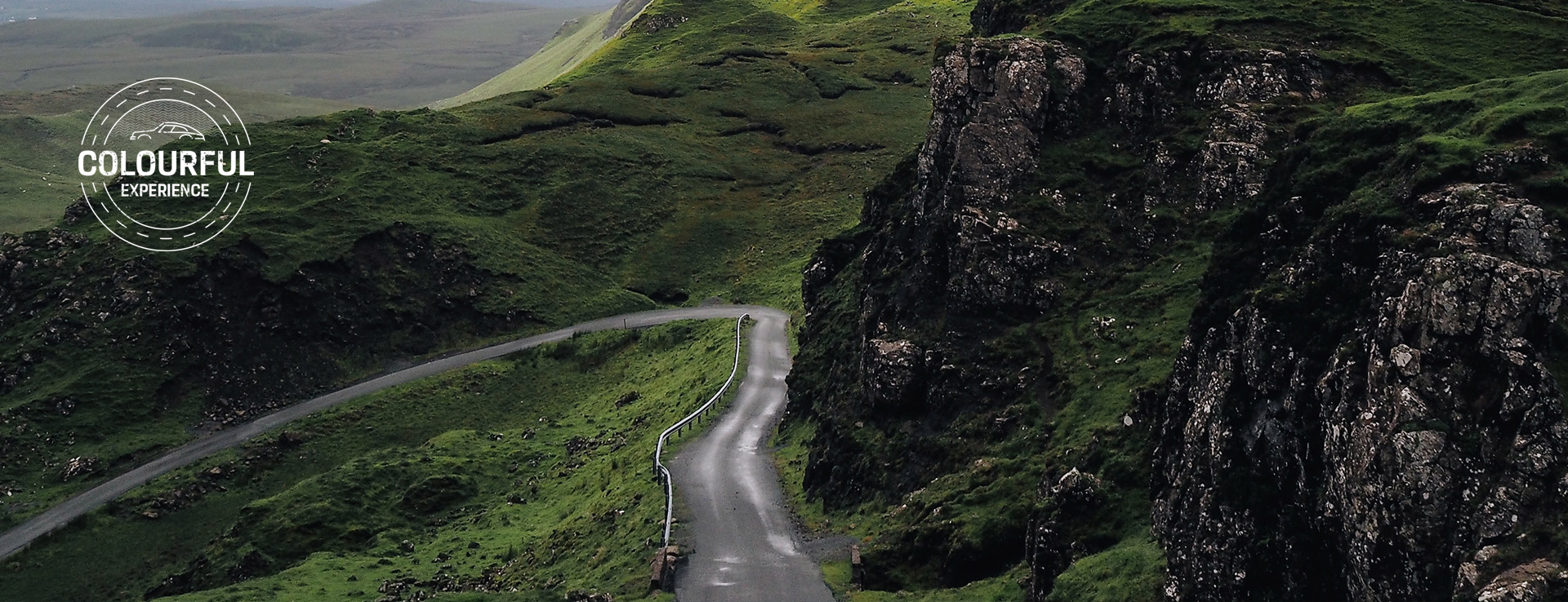 Winding mountainous Irish road passes rugged granite rocks