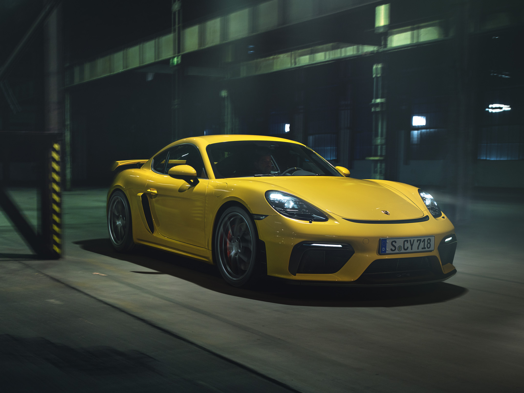 Racing Yellow 718 Cayman GT4 in industrial underground car park