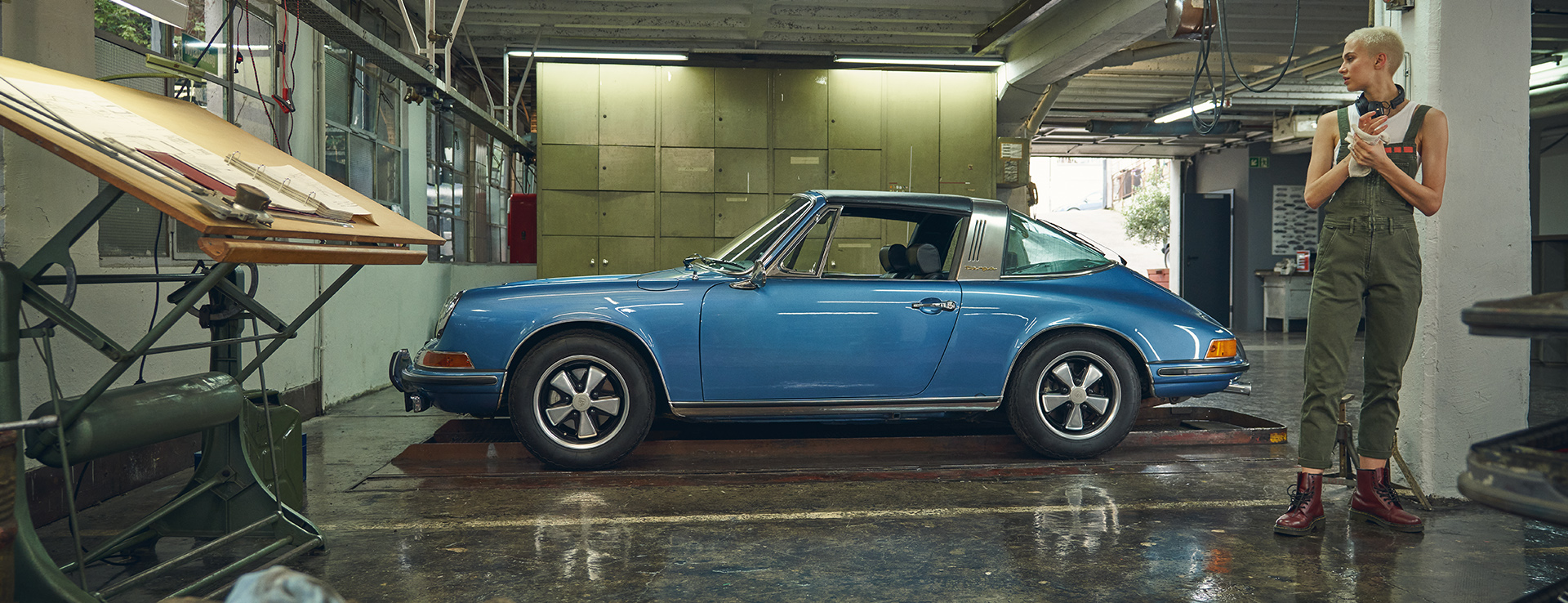 Woman with classic Porsche 911 Targa in a workshop