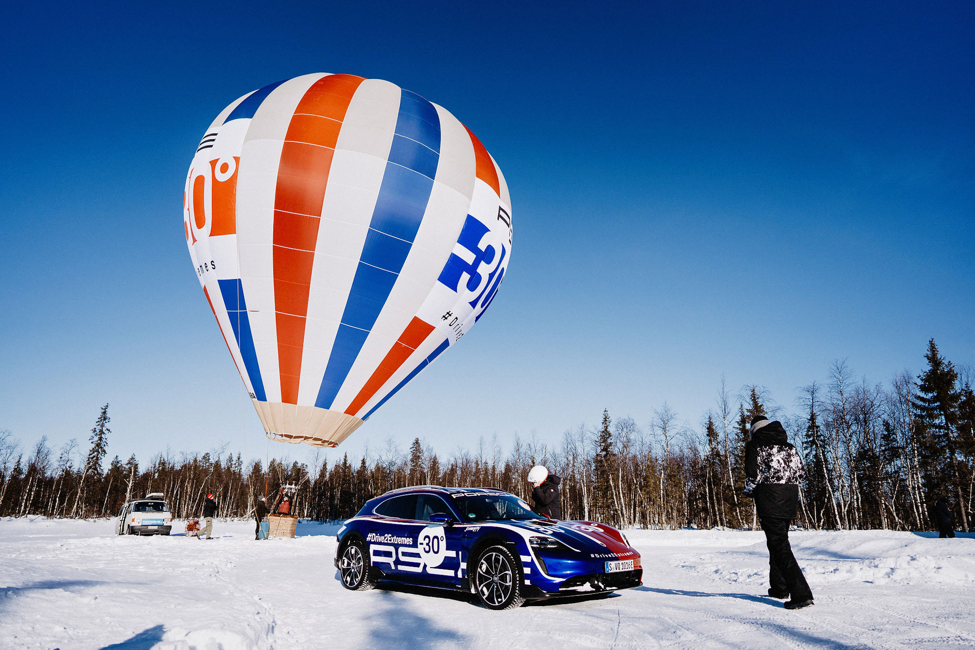Porsche Taycan and hot air balloon in a snowy scene