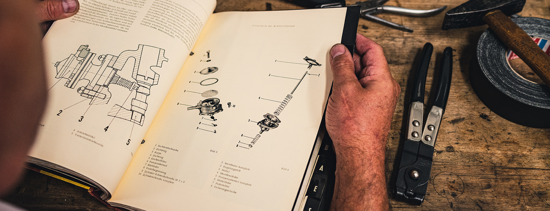 Close-up of man reading classic Porsche car repair manual