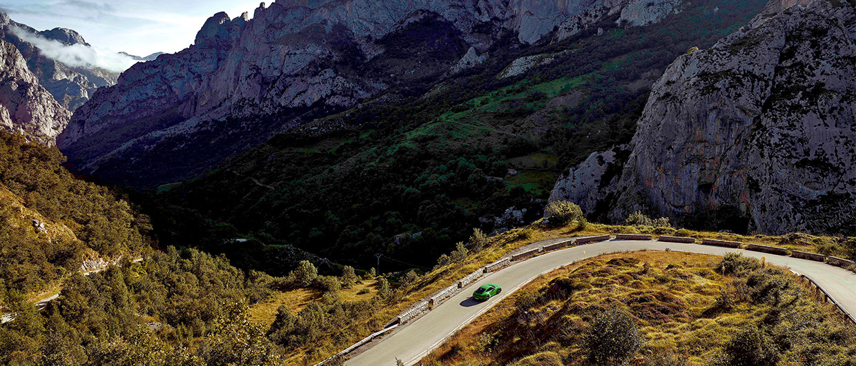 Green Porsche 911 Carrera T on winding mountain road
