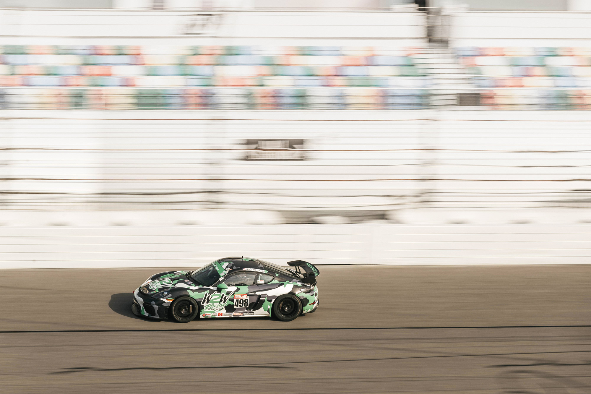 Camo-painted Porsche racing car on the racetrack