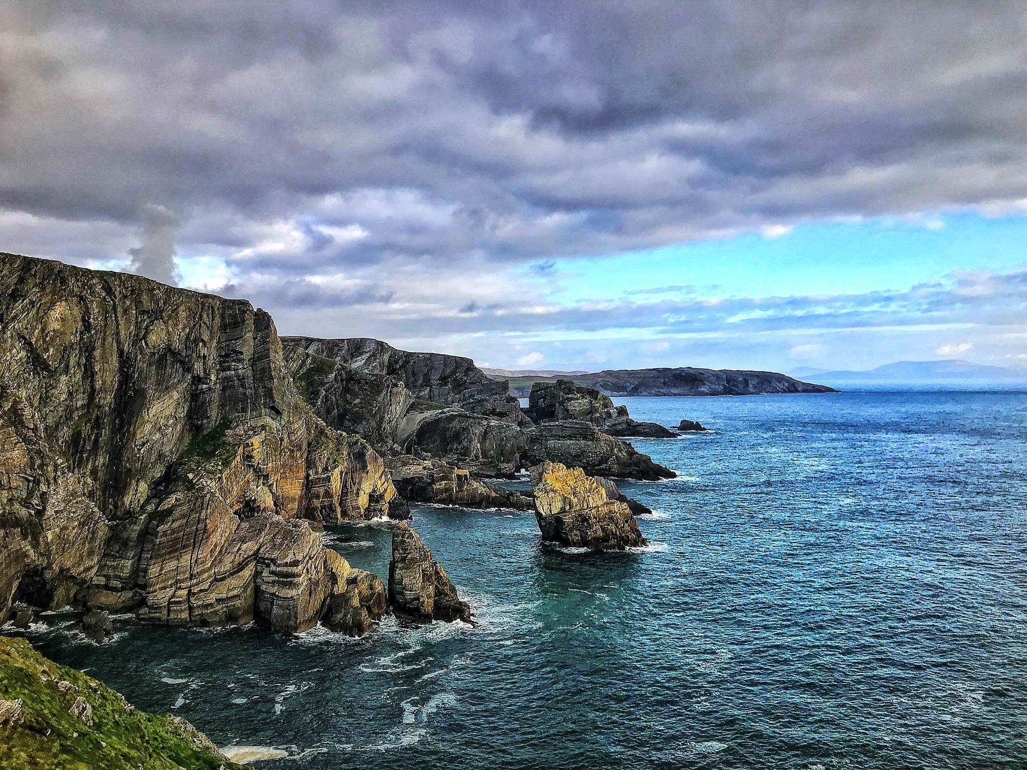 View along rocky granite cliffs, as land meets ocean