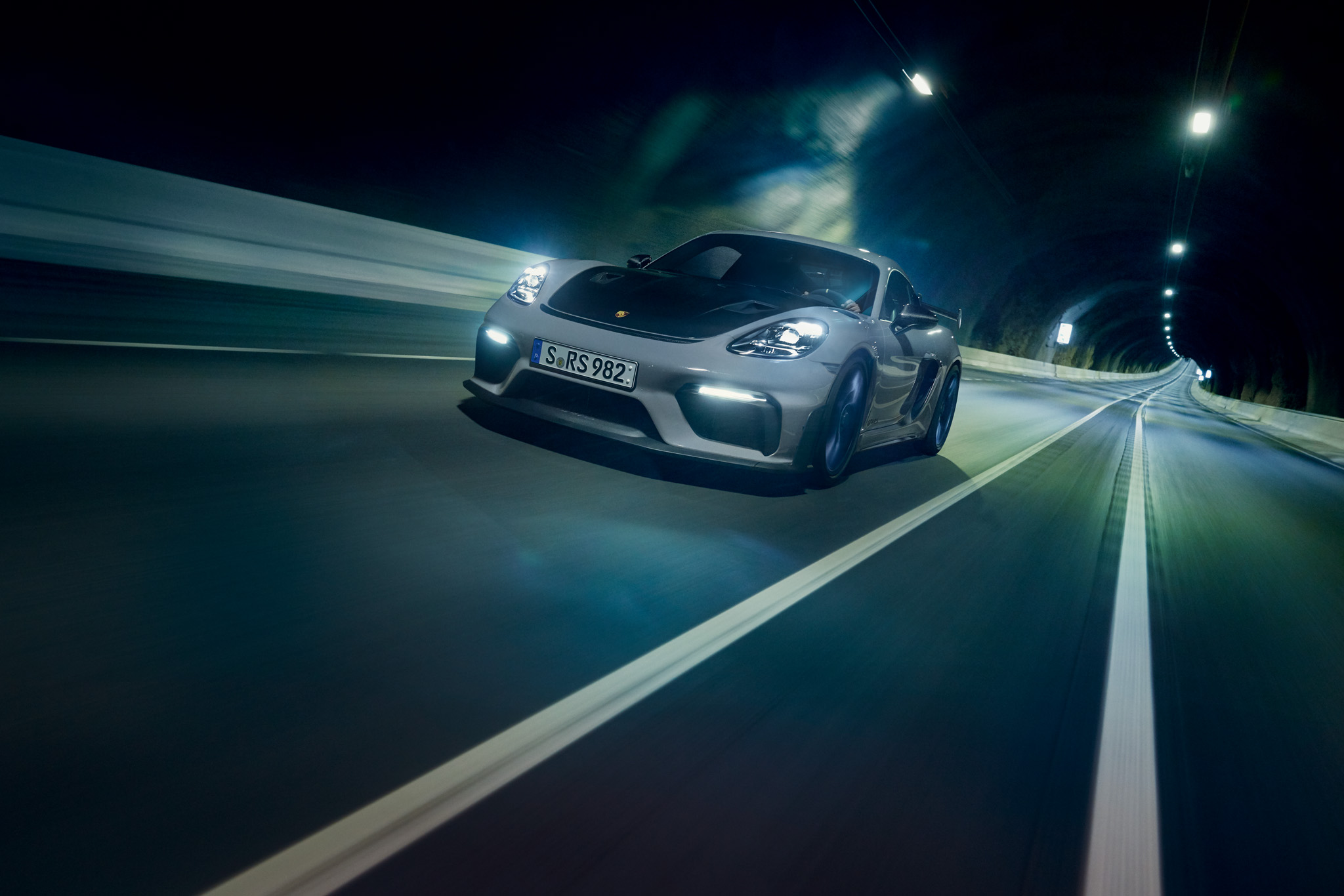 Front view of a Porsche 718 Cayman GT4 RS driving through a tunnel