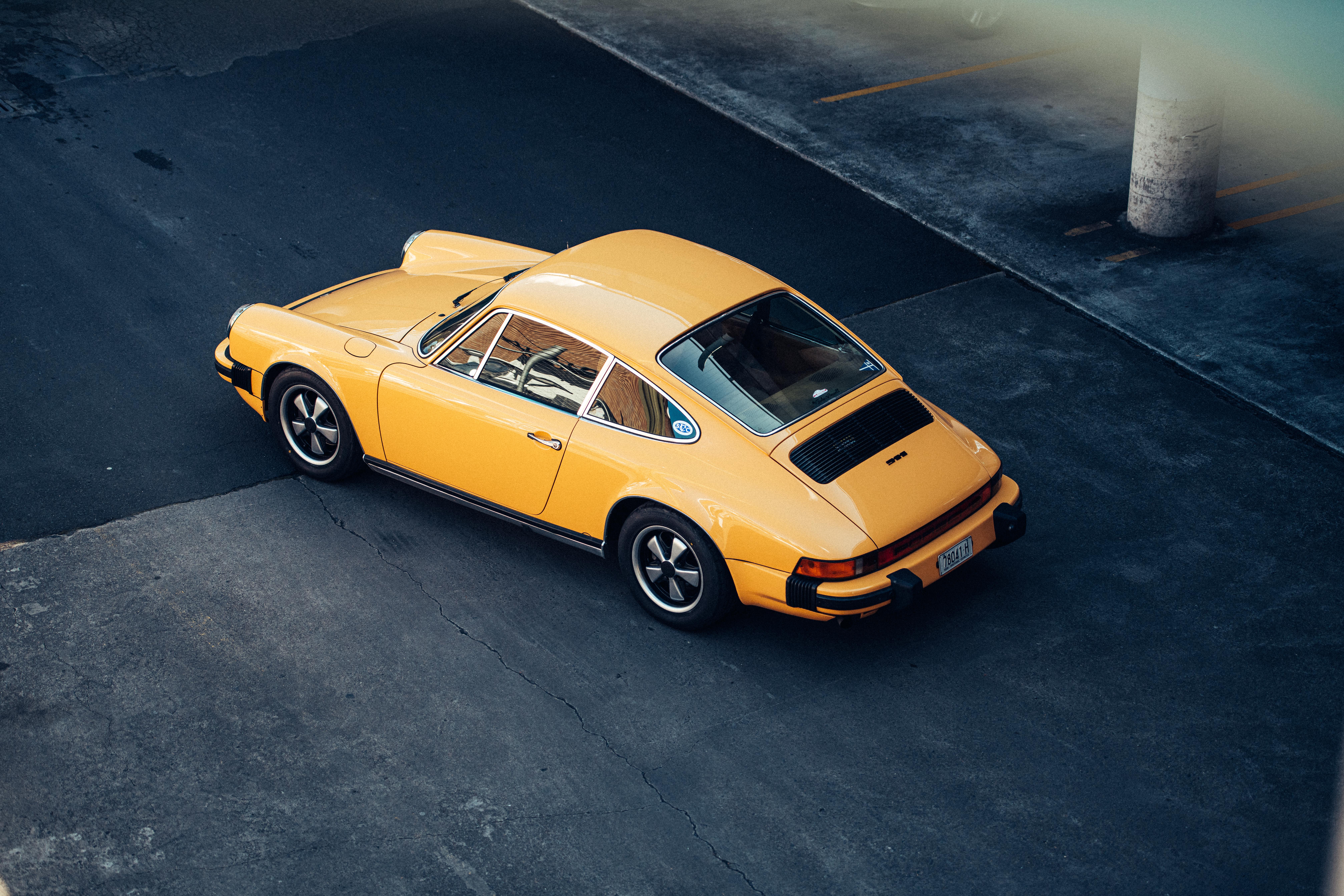 Aerial view of yellow classic Porsche 911 in parking lot