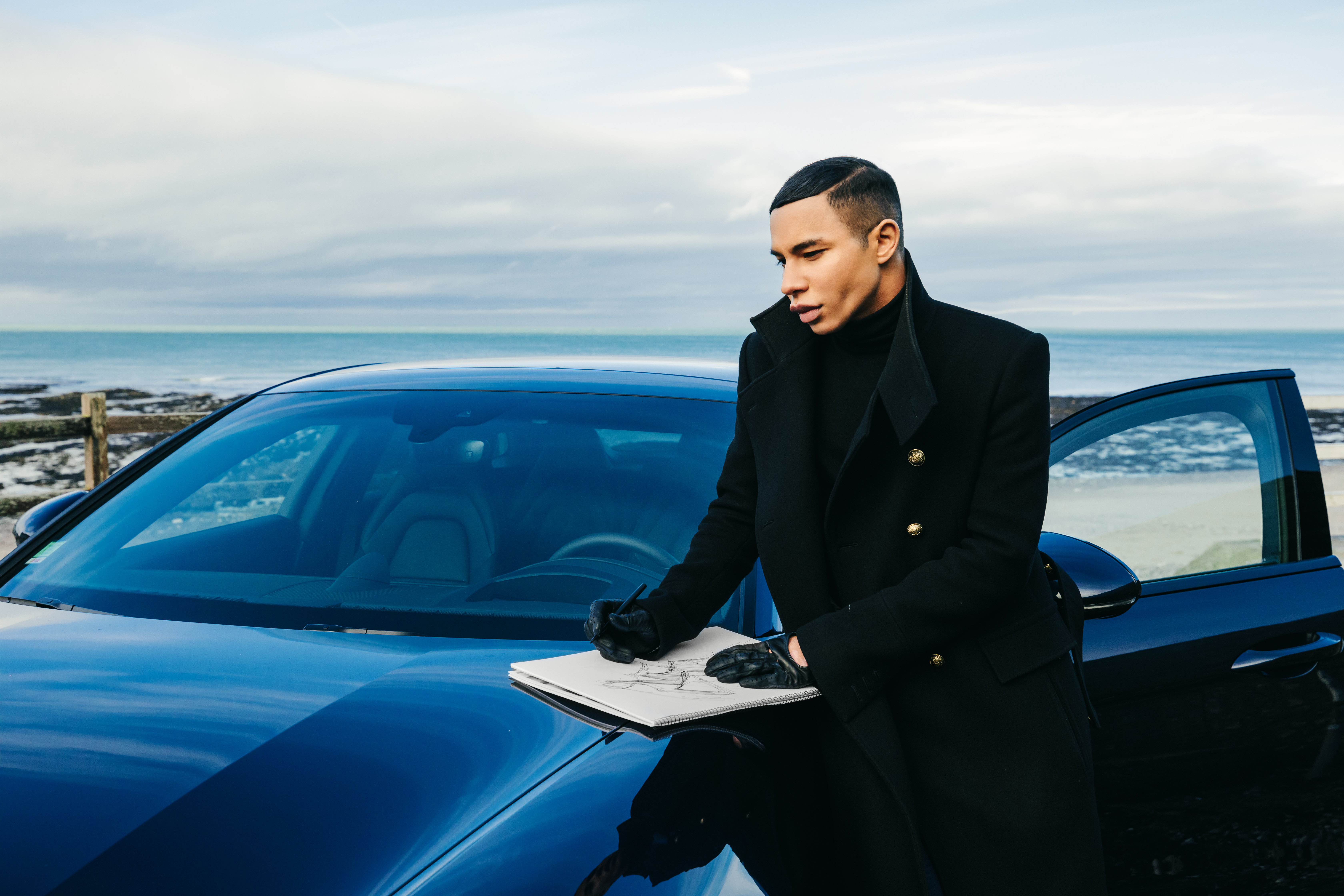 Olivier Rousteing sketching on the bonnet of a car