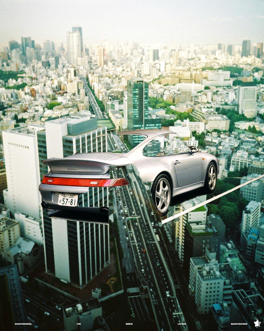 Silver Porsche 911 with city skyline edited through the car