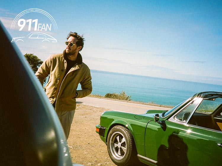 Man next to green Porsche 911 Targa, ocean in background