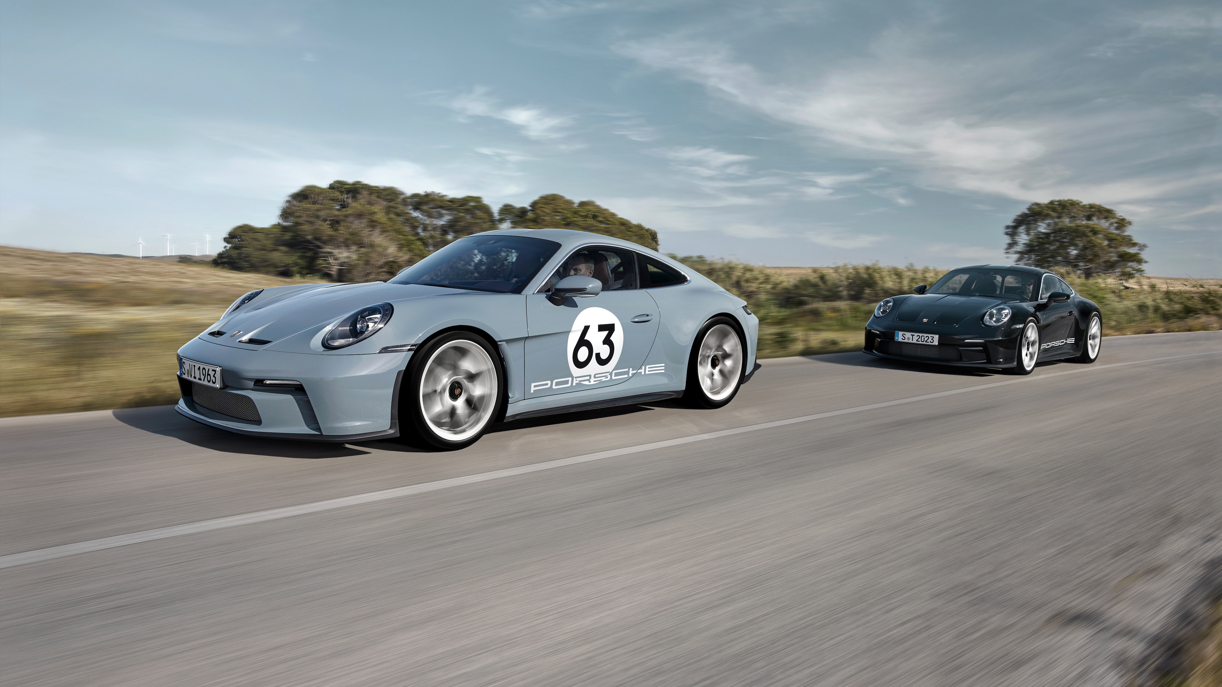Two Porsche 911 S/T cars driving on the road