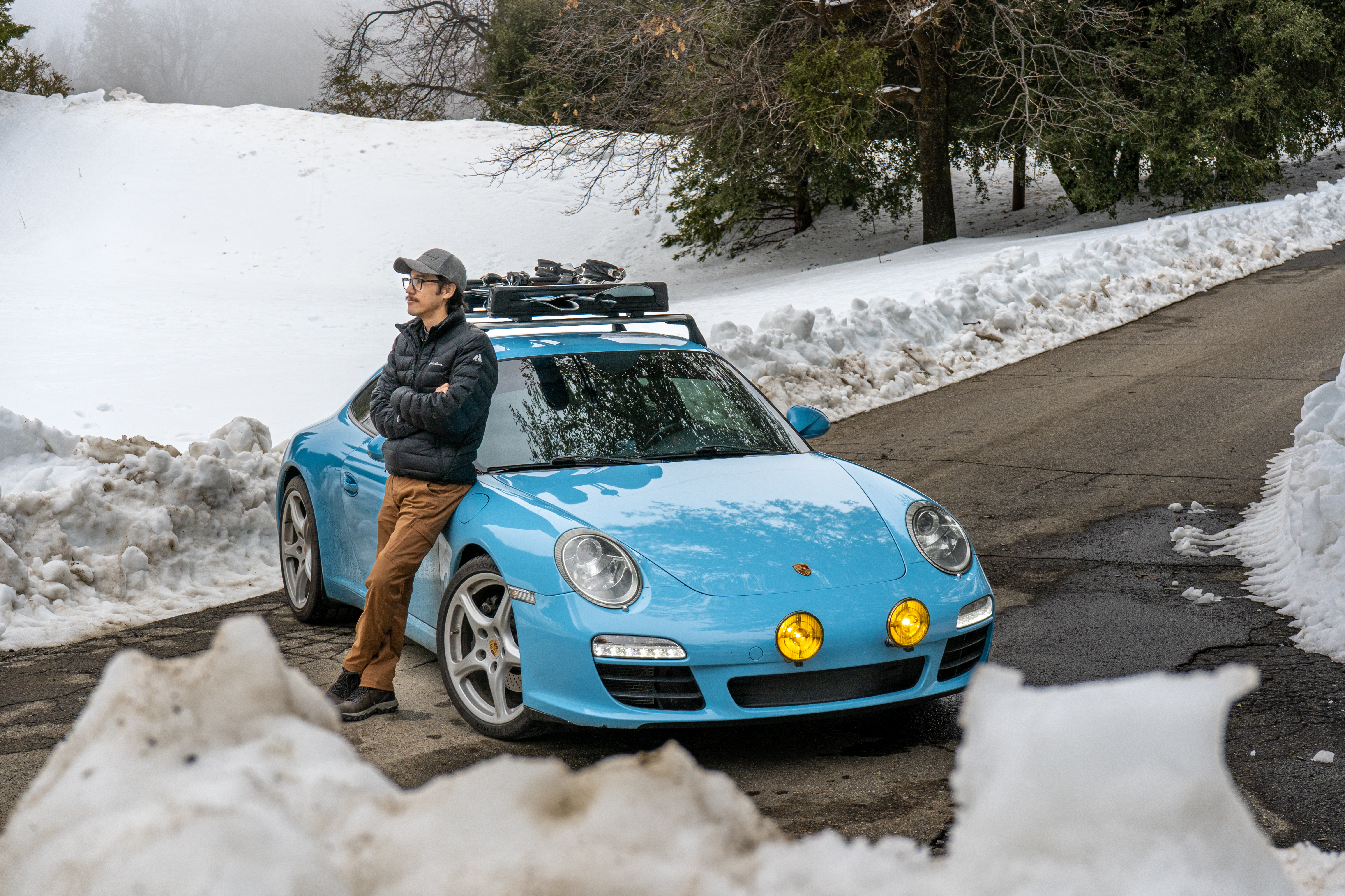 Porsche 911 (type 997), headlights on, on a snowy road