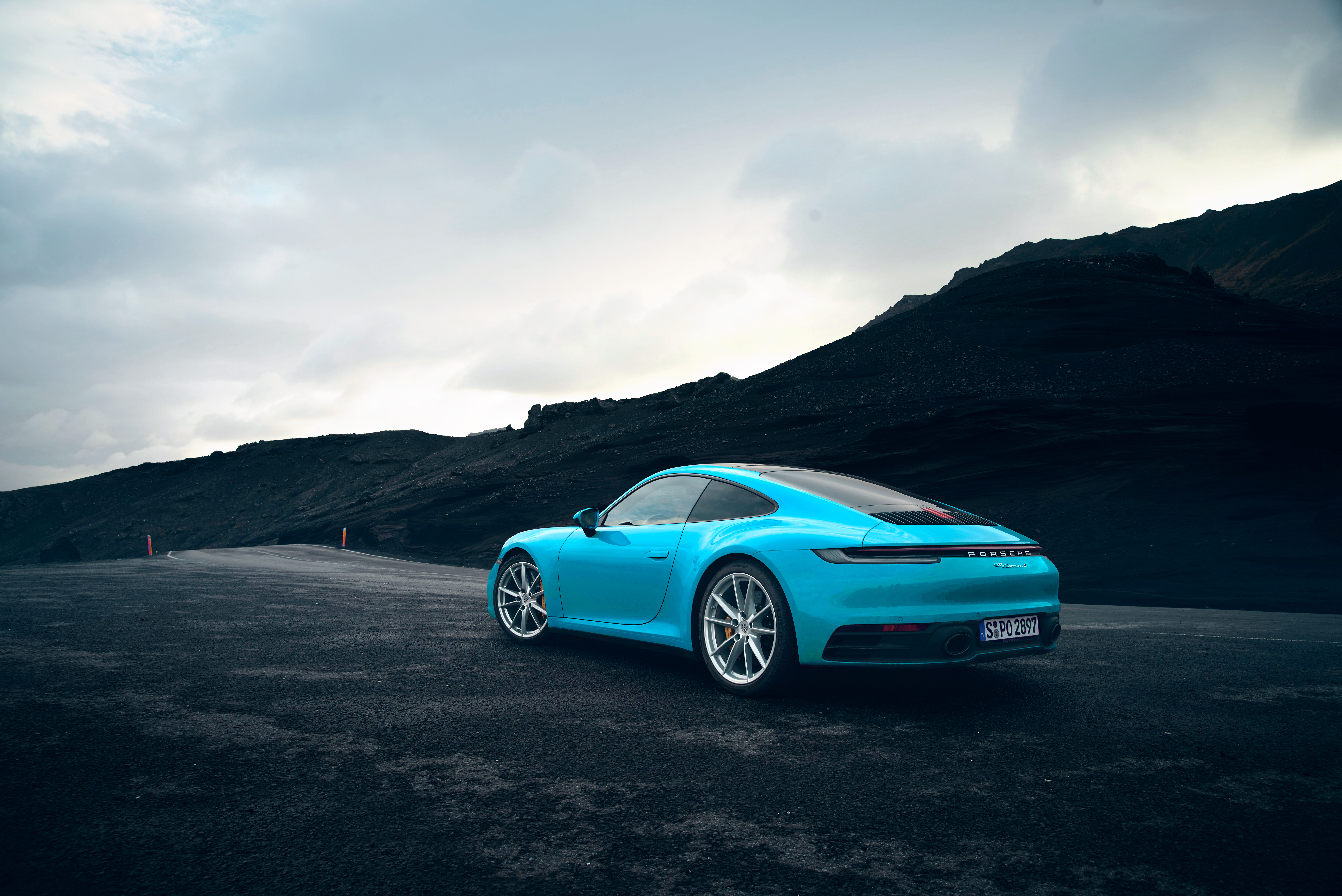 Blue sports car in front of a rocky landscape