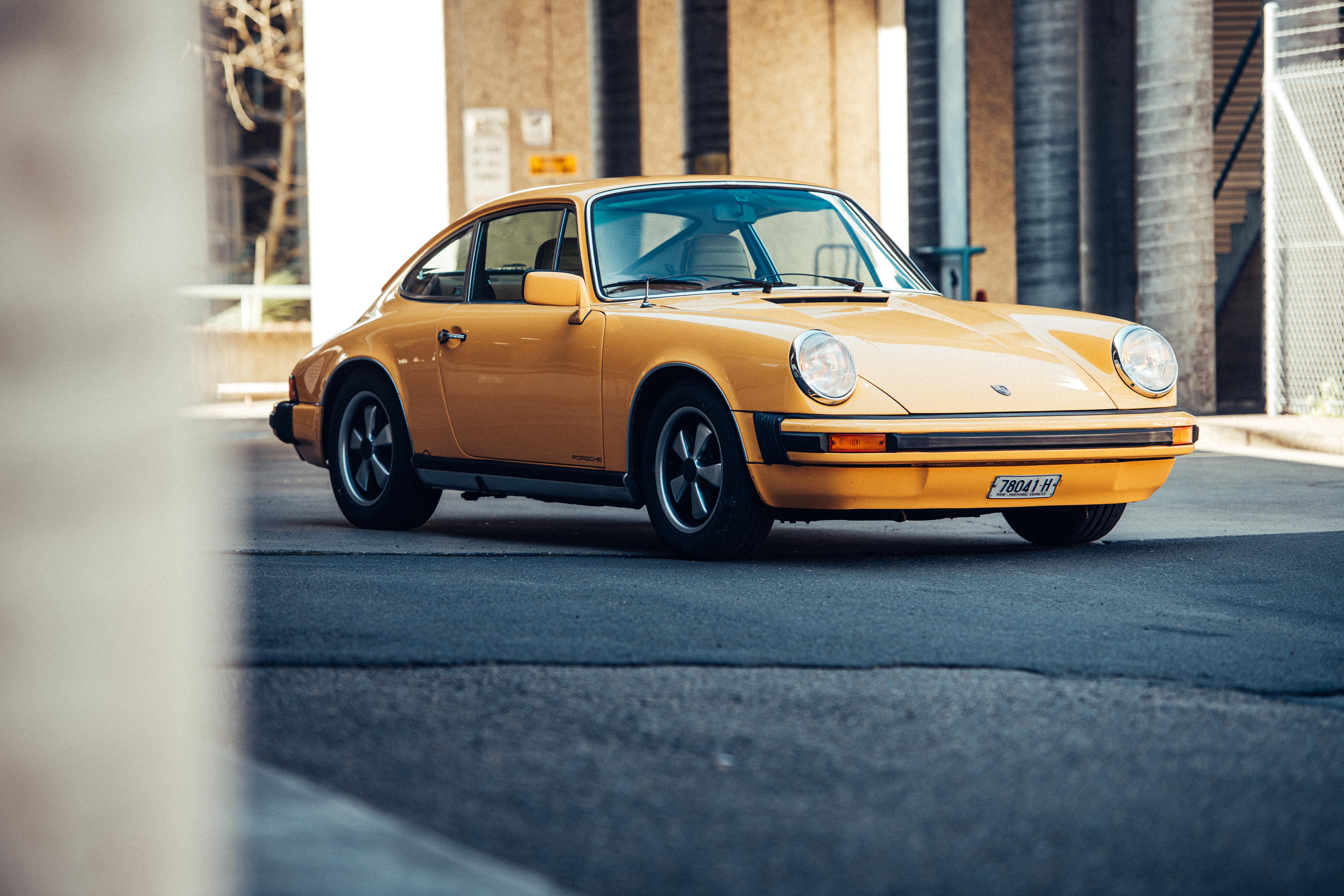 Classic bright yellow Porsche 911 parked in street