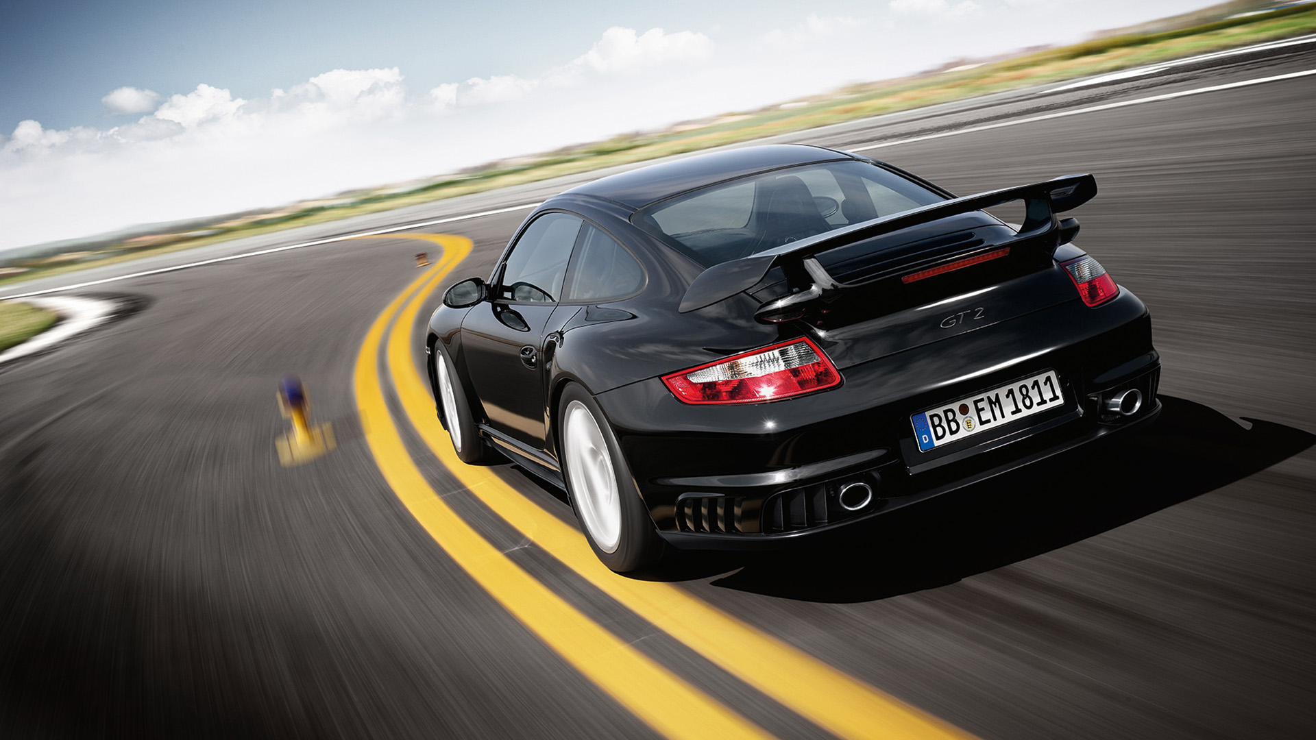 Rear view of Porsche 911 GT2 type 997 black on racetrack_desktop