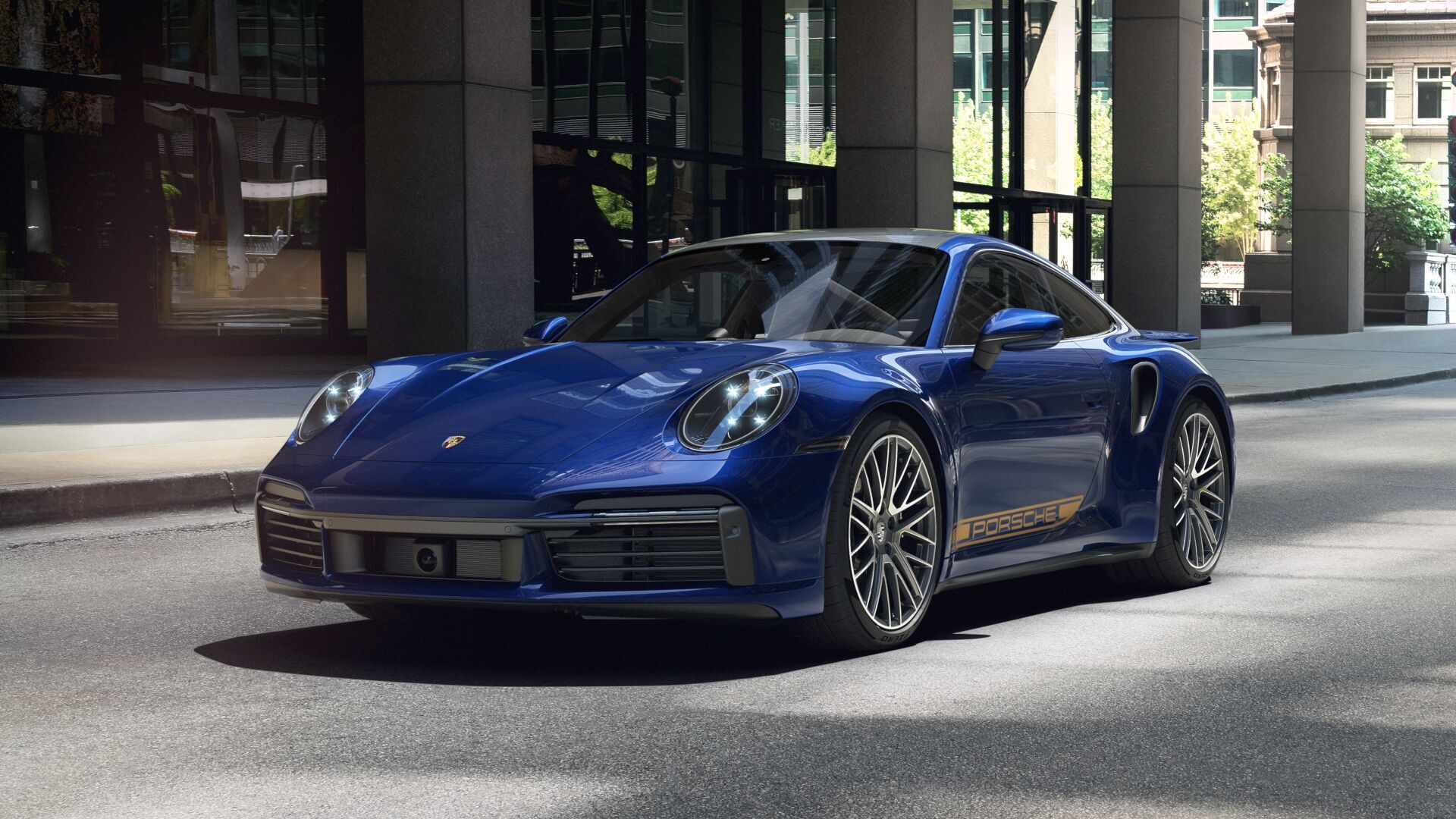 Gentian Blue Porsche 911 Turbo S in front of a city office building