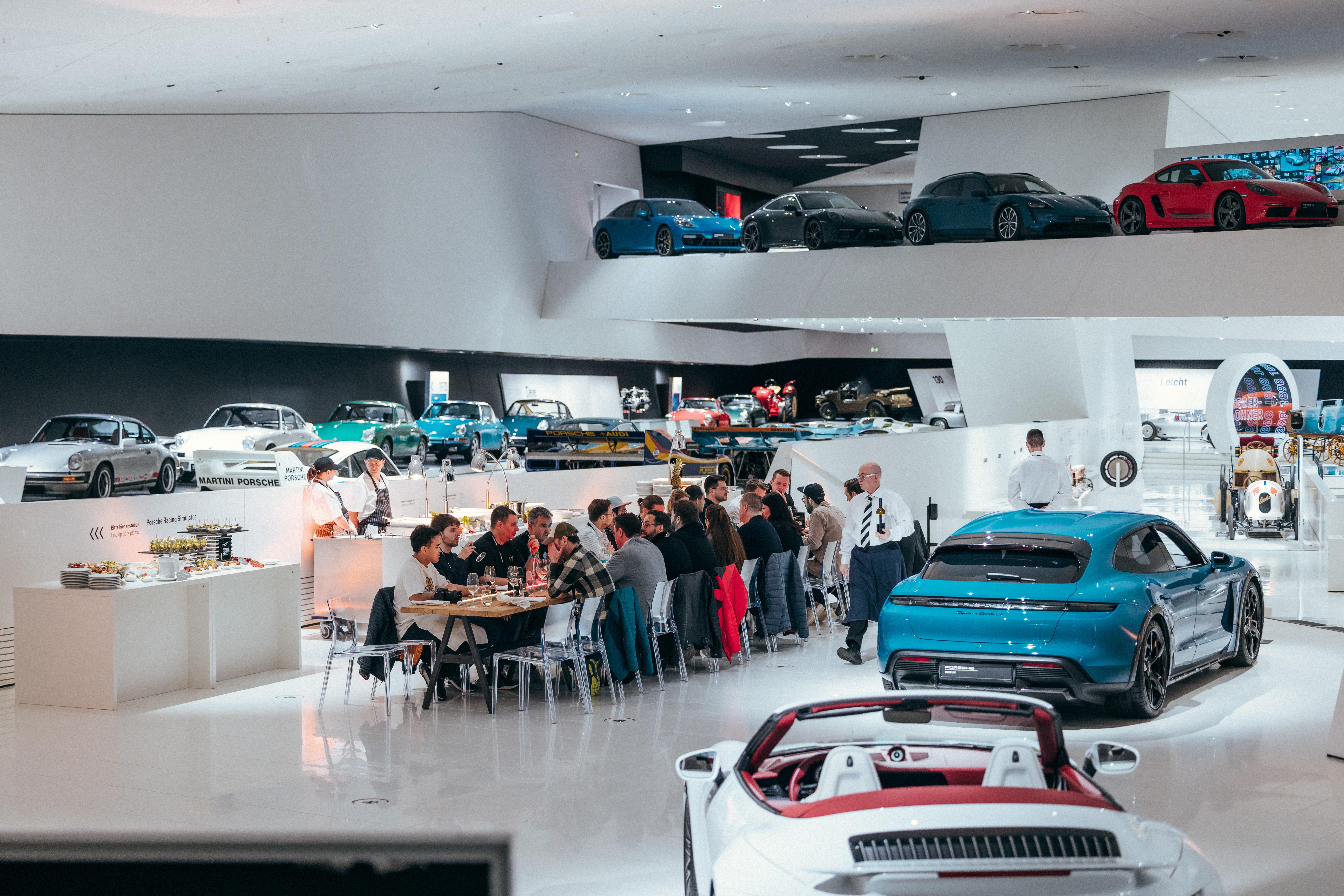 Long dining table filled with people in Porsche museum