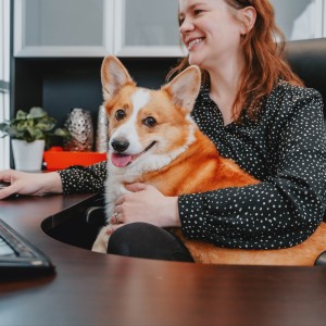 Woman sitting using a computer with a dog in her lap