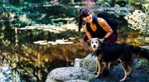 Black and brown dog and pet parent by pond