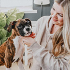 Woman petting boxer puppy