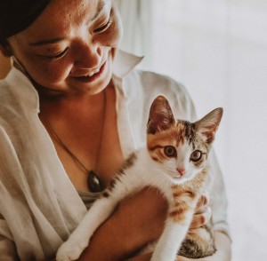 穿白色上衣的女人抱着小花猫