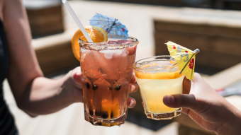 Two people cheering two cocktails