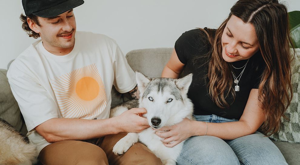 Couple on couch with Husky dog
