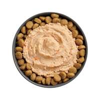 Bowl of kibble topped with Go! Booster Carnivore Chicken, Salmon + Duck Pâté for dogs